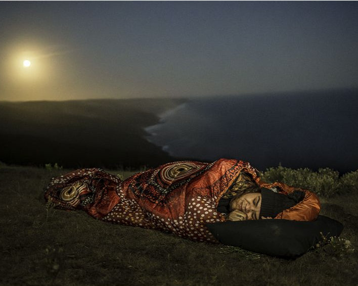 Aboriginal woman sleeping in an the rockhole dreaming sleeping bag